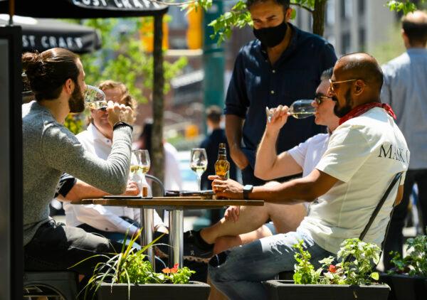 People enjoy drinks and friends on an outdoor patio in downtown Toronto on June 11, 2021. (Nathan Denette/The Canadian Press)