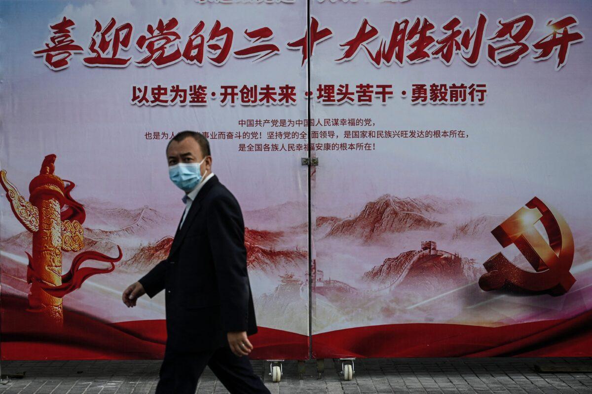A man walks past a propaganda poster welcoming the 20th Communist Party Congress meeting along a street in Beijing on Sept. 21, 2022. (Jade Gao/AFP via Getty Images)