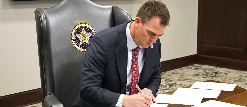 Oklahoma Gov. Kevin Stitt signs documents in an undated photo downloaded on Oct. 14, 2022. (Courtesy of State of Oklahoma)