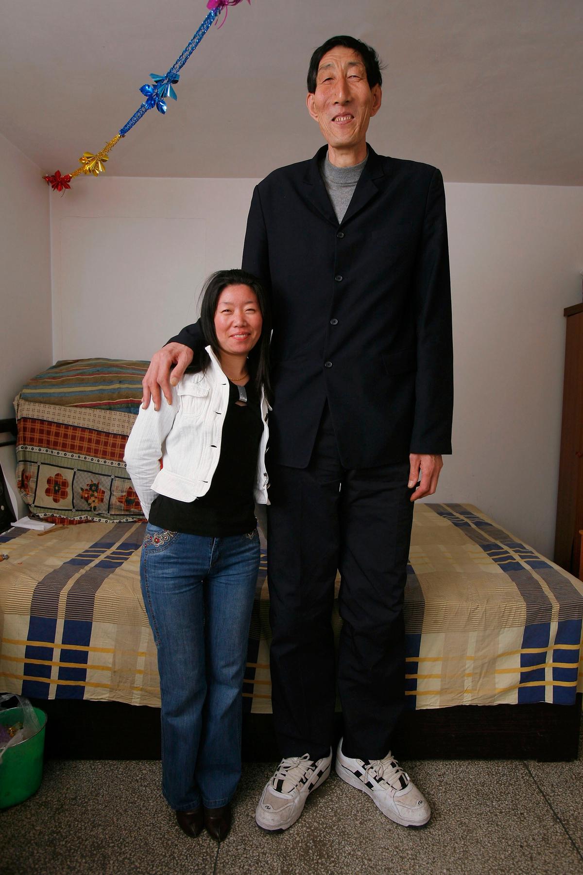 Formerly the world's tallest man, Bao Xishun (R) poses for a photo with his bride Xia Shujuan at home on March 30, 2007, in Chifeng of Inner Mongolia Autonomous Region, China.  (China Photos/Getty Images)