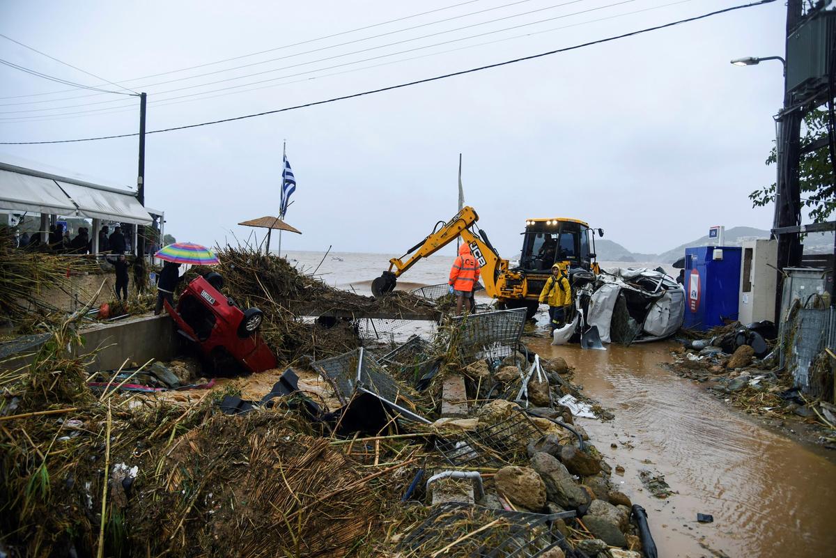 Workers try to clear an area following heavy thunderstorms, in the village of Agia Pelagia, on the island of Crete, Greece, on Oct. 15, 2022. (Harry Nakos/AP Photo)