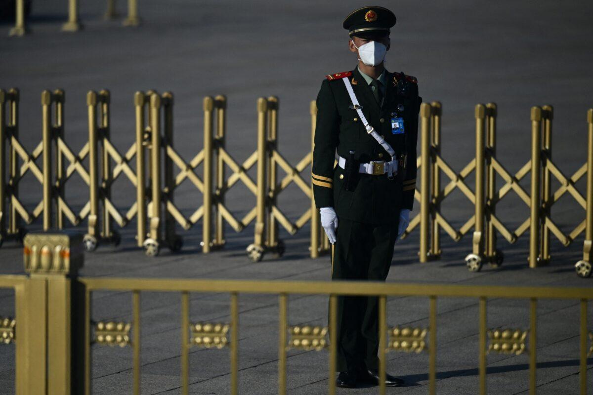  A security member keeps watch on Tiananmen Square, ahead of the opening session of a five-year Chinese Communist Party political conference in Beijing on Oct. 16, 2022. (Noel Celis/AFP via Getty Images)