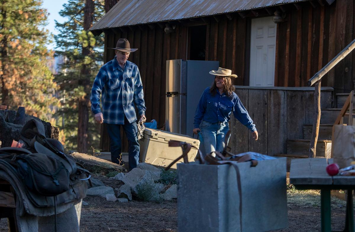 Lead packer Chelsea McGlyn (R) and Los Angeles Times reporter Doug Smith (L) carry an ice chest to a waiting mule as they pack up for a wilderness trip at the Golden Trout Pack Station, on July 5, 2022, in Sequoia National Forest, Calif. (Courtesy of Brian van der Brug/Los Angeles Times/TNS)
