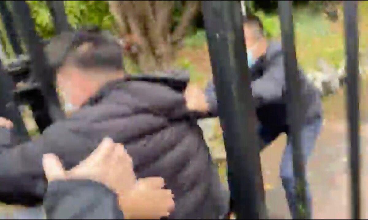 The staff from the Chinese Consulate (right) pulled the anti-CCP protesters from outside the Consulate to inside the consulates iron gate. (Screenshot of video)