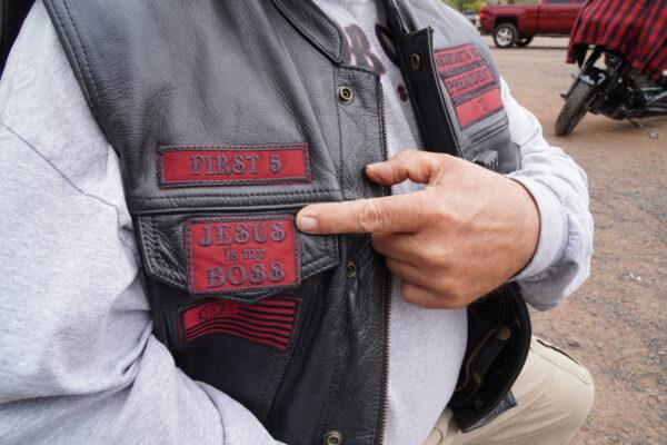 Ascendants Motorcycle Club president Terry "T" Donahue points to a patch indicating his faith on Oct. 15, 2022. (Allan Stein/The Epoch Times)