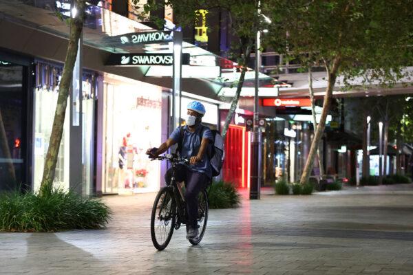 A food delivery rider cycles down a deserted Murray Street mall in Perth, Australia, on Jan. 31, 2021. (Paul Kane/Getty Images)