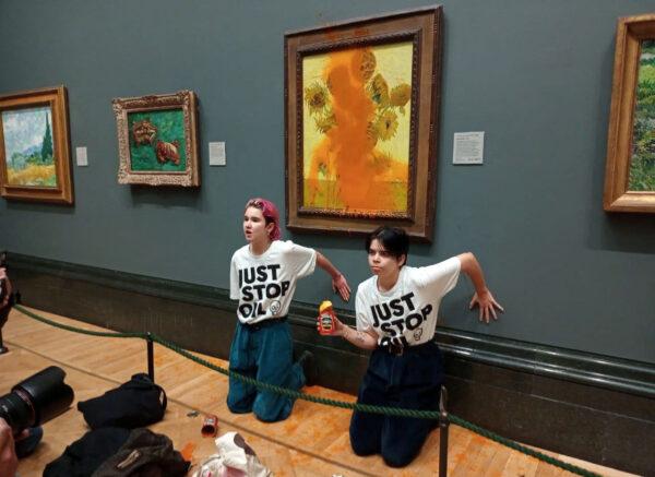 Activists with Just Stop Oil glue their hands to the wall after throwing soup at Vincent van Gogh's "Sunflowers" at the National Gallery in London, on Oct. 14, 2022. (Just Stop Oil/Handout via Reuters)
