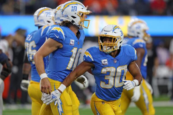 Austin Ekeler (30) and Justin Herbert (10) of the Los Angeles Chargers celebrate a touchdown against the Denver Broncos during the second quarter at SoFi Stadium in Inglewood, Calif., on Oct. 17, 2022. (Harry How/Getty Images)