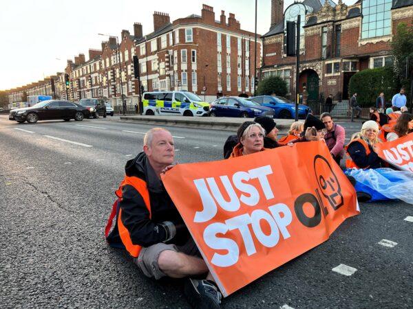 Activists with the Just Stop Oil climate campaign group hold a banner at Barons Court in west London as they block the A4 during a series of actions in the city on Oct. 18, 2022. (Adrian Dennis/AFP via Getty Images)