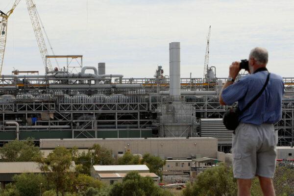 A tourist (R) photographs the gas production area at the Woodside operated North West Shelf Gas Venture near Karratha in the north of Western Australia on June 16, 2008. (Photo by GREG WOOD/AFP via Getty Images)