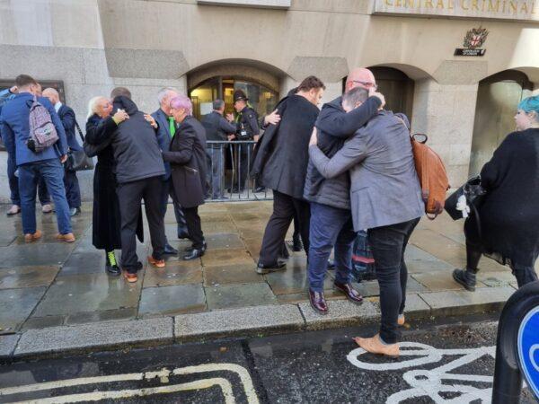 Harry Dunn's parents Charlotte (far left, hugging) and Tim (right, with glasses, hugging) celebrate outside the Old Bailey in London, on Oct. 20, 2022. (Chris Summers/The Epoch Times)