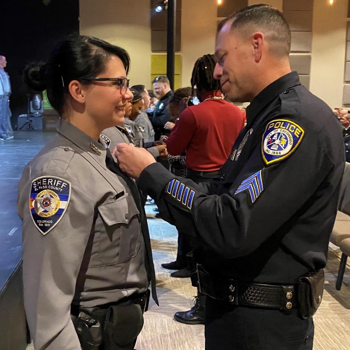 Sgt. Jeff Valdivia pins a badge on Dep. Natalie Young's shirt during her graduation from the El Paso County Sheriff’s Academy, 22 years after saving her life. (Courtesy of <a href="http://www.epcounty.com/sheriff/">El Paso County Sheriff’s Office</a>)