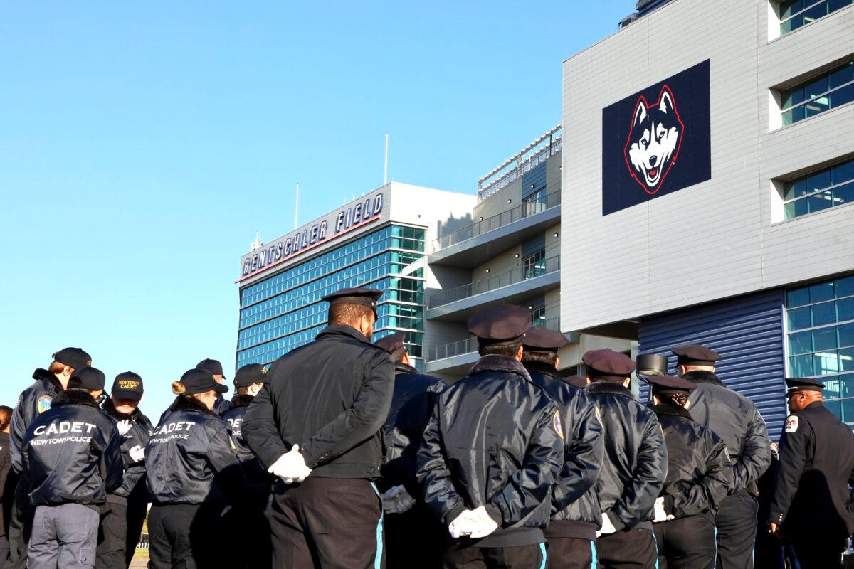Police officers file into Pratt & Whitney Stadium at Rentschler Field for a funeral service for Bristol Police officers Dustin DeMonte and Alex Hamzy in East Hartford, Conn. on Oct. 21, 2022. (Sean Fowler/Hartford Courant via AP)
