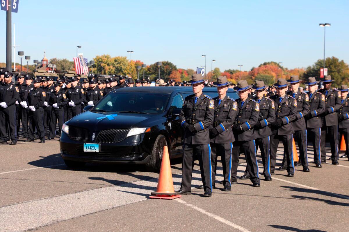 Police line the path as the hearses for Bristol Police officers Dustin DeMonte and Alex Hamzy arrive at a funeral service in East Hartford, Conn., on Oct. 21, 2022. (Sean Fowler/Hartford Courant via AP)
