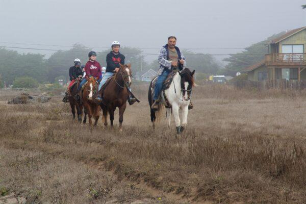An equestrian guide leads a small group of riders alongside the coastal trail. (Courtesy of Karen Gough)