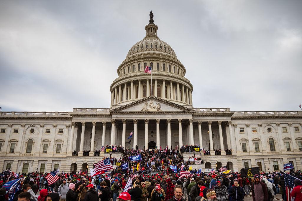 A large group of protesters stand on the East steps of the Capitol Building after breaching its grounds in Washington on Jan. 6, 2021. (Jon Cherry/Getty Images)