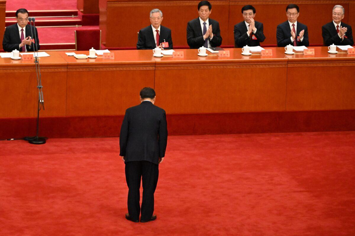 (Back L–R) China's Premier Li Keqiang, former leader Hu Jintao, Politburo Standing Committee members Li Zhanshu, Wang Huning, Han Zheng and former premier Wen Jiabao applaud as China's leader Xi Jinping bows to delegates before delivering a speech during the opening session of the 20th Chinese Communist Party's Congress at the Great Hall of the People in Beijing on Oct. 16, 2022. (Noel Celis/AFP via Getty Images)