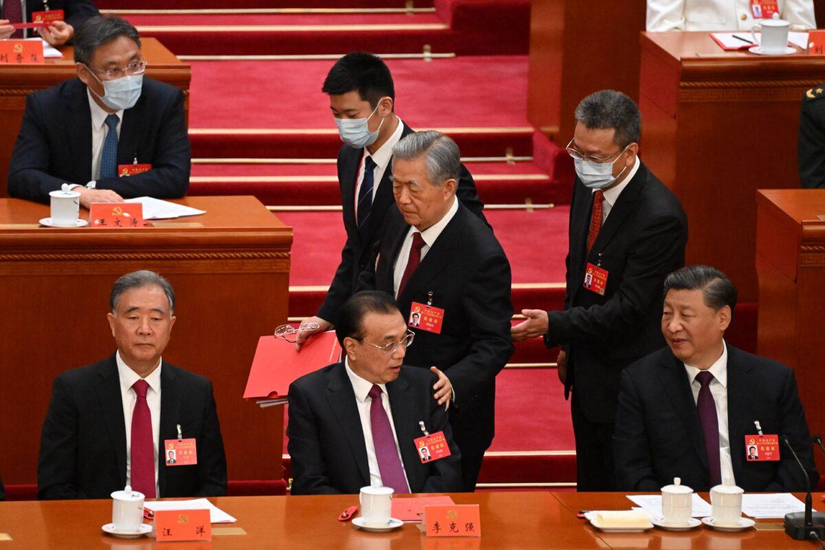 China's leader Xi Jinping (R) watches as former leader Hu Jintao (C) touches the shoulder of Premier Li Keqiang (2nd L) as he leaves the closing ceremony of the 20th Chinese Communist Party's Congress at the Great Hall of the People in Beijing on Oct. 22, 2022. (Noel Celis/AFP via Getty Images)