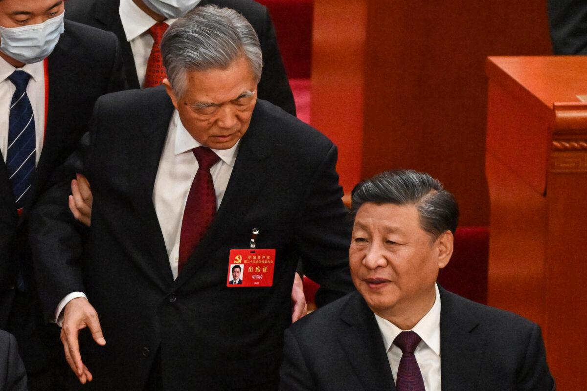 Xi Jinping (R) talks to former leader Hu Jintao as he is assisted to leave the closing ceremony of the 20th Chinese Communist Party’s Congress at the Great Hall of the People in Beijing on Oct. 22, 2022. (Noel Celis/AFP via Getty Images)