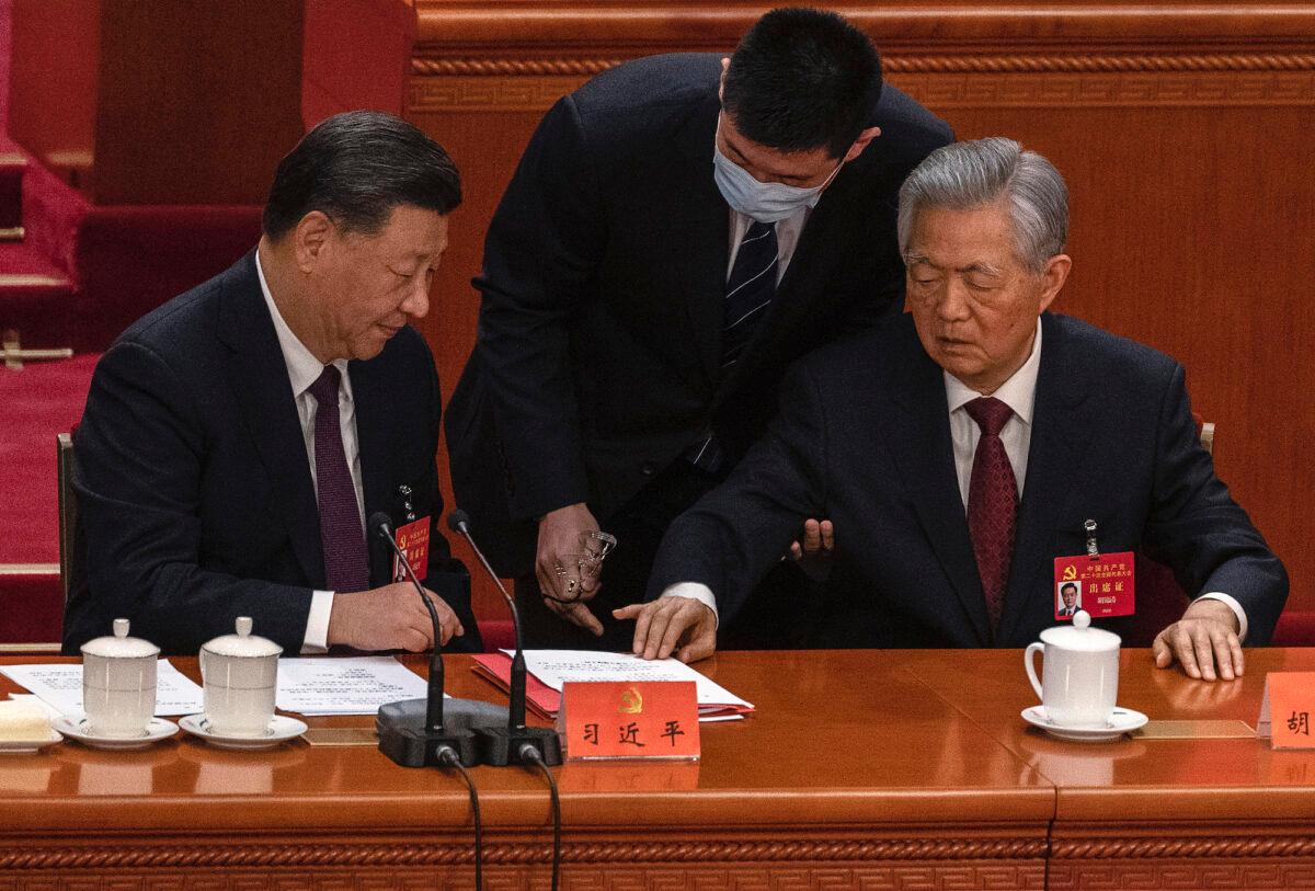 Chinese leader Xi Jinping looks on as former leader Hu Jintao (R) gestures as he is helped to leave early from the closing session of the 20th Chinese Communist Party Congress at The Great Hall of People in Beijing, on Oct. 22, 2022. (Kevin Frayer/Getty Images)