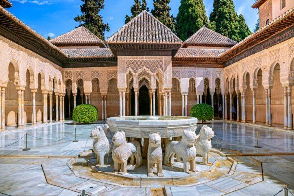 One of the most famous sights of the Alhambra is the Courtyard of the Lions in the Palace of the Lions. The oblong court is surrounded by an ornate gallery with stucco filigree walls and a wooden domed ceiling supported by 124 white slender marble columns. In the center of the court is an alabaster basin, surrounded by 12 white marble lions, which symbolize strength and courage. (<a href="https://www.shutterstock.com/g/mrssippy">Pani Garmyder</a>/<a href="https://www.shutterstock.com/image-photo/alhambra-granada-spain-30-march-2019-1667100517">Shutterstock</a>)
