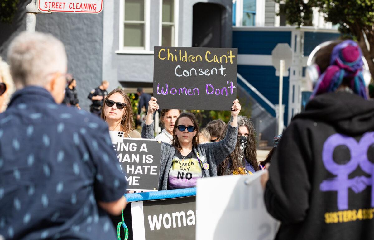 Activists against transgender policies for children hold up protest signs in San Francisco on Oct. 22, 2022. (John Fredricks/The Epoch Times)