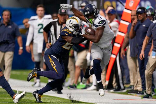 Los Angeles Chargers cornerback J.C. Jackson (27) pushes Seattle Seahawks running back Kenneth Walker III (9) out of bounds during the first half of an NFL football game in Inglewood, Calif., on Oct. 23, 2022. (Mark J. Terrill/AP Photo)
