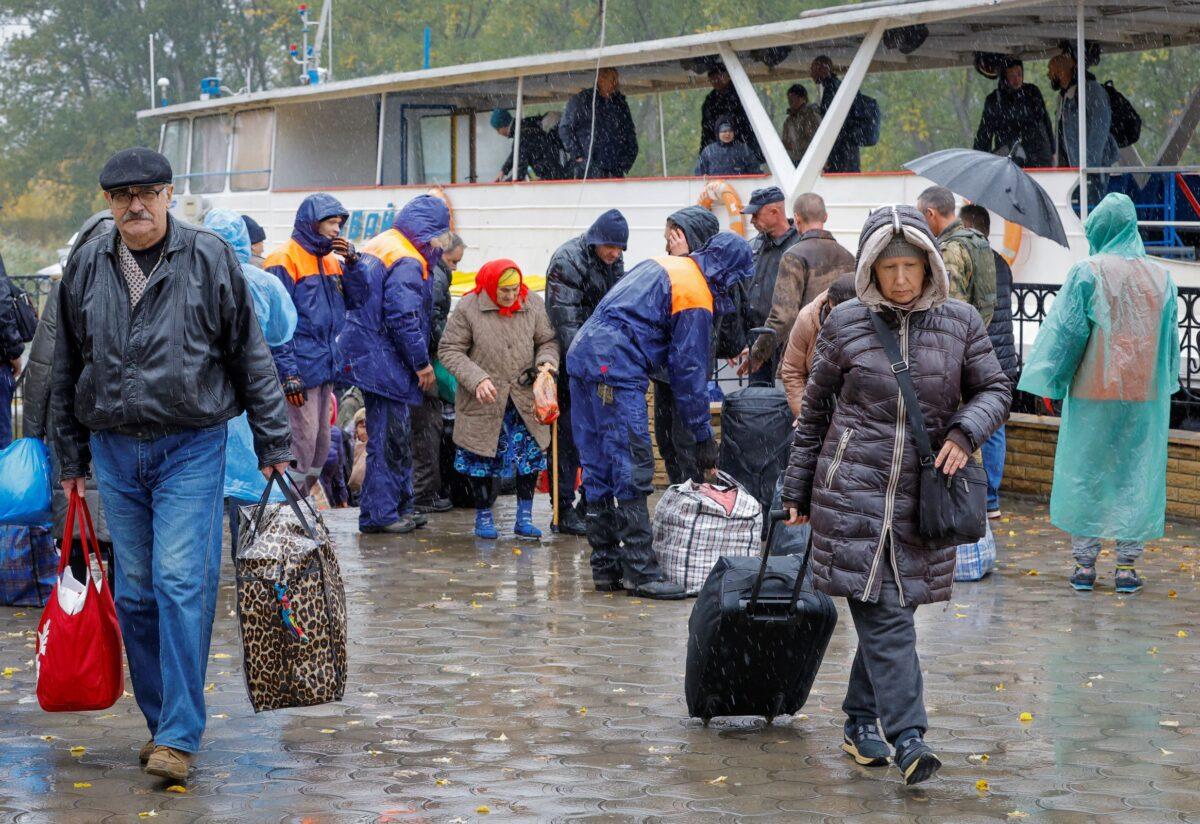 Civilians evacuated from the Russian-controlled city of Kherson walk from a ferry to board a bus heading to Crimea, in the town of Oleshky, Kherson region, Russian-controlled Ukraine, on Oct. 23, 2022. (Alexander Ermochenko)