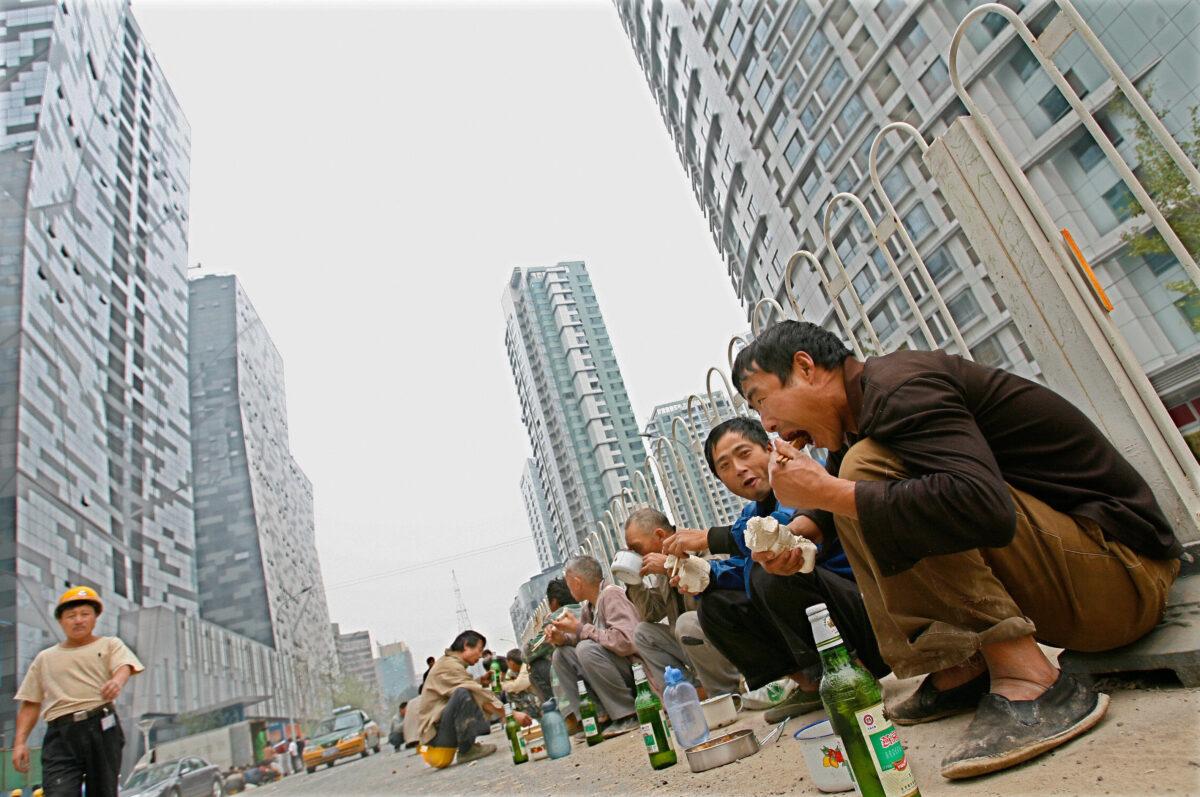 Chinese workers eat their lunch at the construction site of commercial and luxury residential buildings in central Beijing, 26 September 2007. (Teh Eng Koon/AFP via Getty Images)