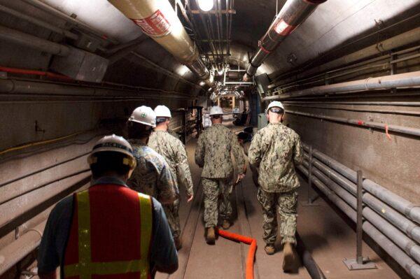 Rear Adm. John Korka, Commander, Naval Facilities Engineering Systems Command (NAVFAC), and Chief of Civil Engineers, leads Navy and civilian water quality recovery experts through the tunnels of the Red Hill Bulk Fuel Storage Facility, near Pearl Harbor, Hawaii on Dec. 23, 2021. (Mass Communication Specialist 1st Class Luke McCall/U.S. Navy via AP)