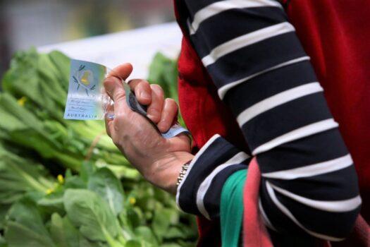 A shopper holds money to make a purchase of fruit and vegetable produce at Paddy's Market in Sydney, Australia on Oct. 22, 2022. (Lisa Maree Williams/Getty Images)