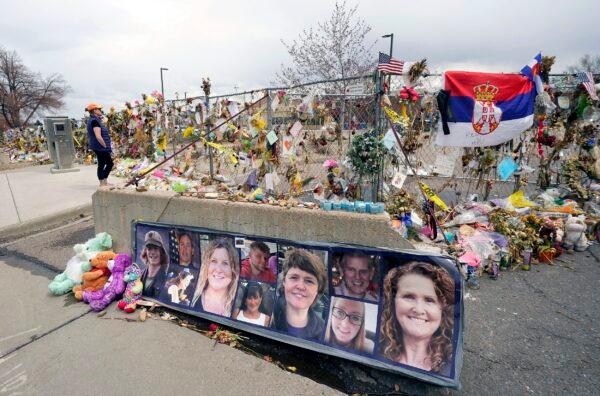 Pictures of the 10 victims of a mass shooting in a King Soopers grocery store are posted on a cement barrier outside the supermarket in Boulder, Colo., on April 23, 2021. (David Zalubowski/AP Photo)