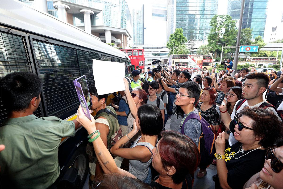 Joshua Wong, Nathan Law, and Alex Chow, three student leaders in the Umbrella Movement, were sentenced to immediate imprisonment on Aug. 17, 2017. A large number of people were outside the court to show their support for the three. (Li Yi/The Epoch Times)