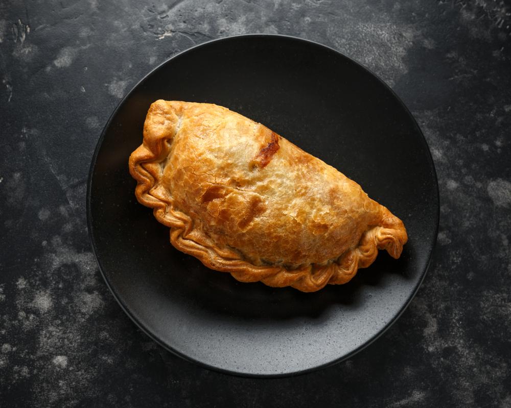 A traditional Cornish pasty, which has PGI status, must be made in Cornwall, in the shape of a D, with beef, turnip, onion, potato, and seasoning.(DronG/Shutterstock)