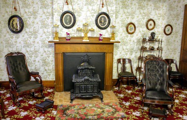 Although Victorian and other 19th-century popular décor styles were present in the floral carpet, wallpaper, and window treatments in the front parlor, practicality is evident in the Lincolns' woven horsehair chairs, chosen for durability and ease-of-care to cover wood-frame seating. <span style="color: #000000;"><span style="color: #333333;">The highly detailed Temple Parlor wood stove is a replica of the home’s original, which is on display at the Henry Ford Museum of Innovation in Dearborn, Michigan, and served as a functional yet decorative room accessory. The circa 19th-century lithographs of George and Martha Washington hold a place of honor over the hearth. (Courtesy of the National Park Service)</span></span>