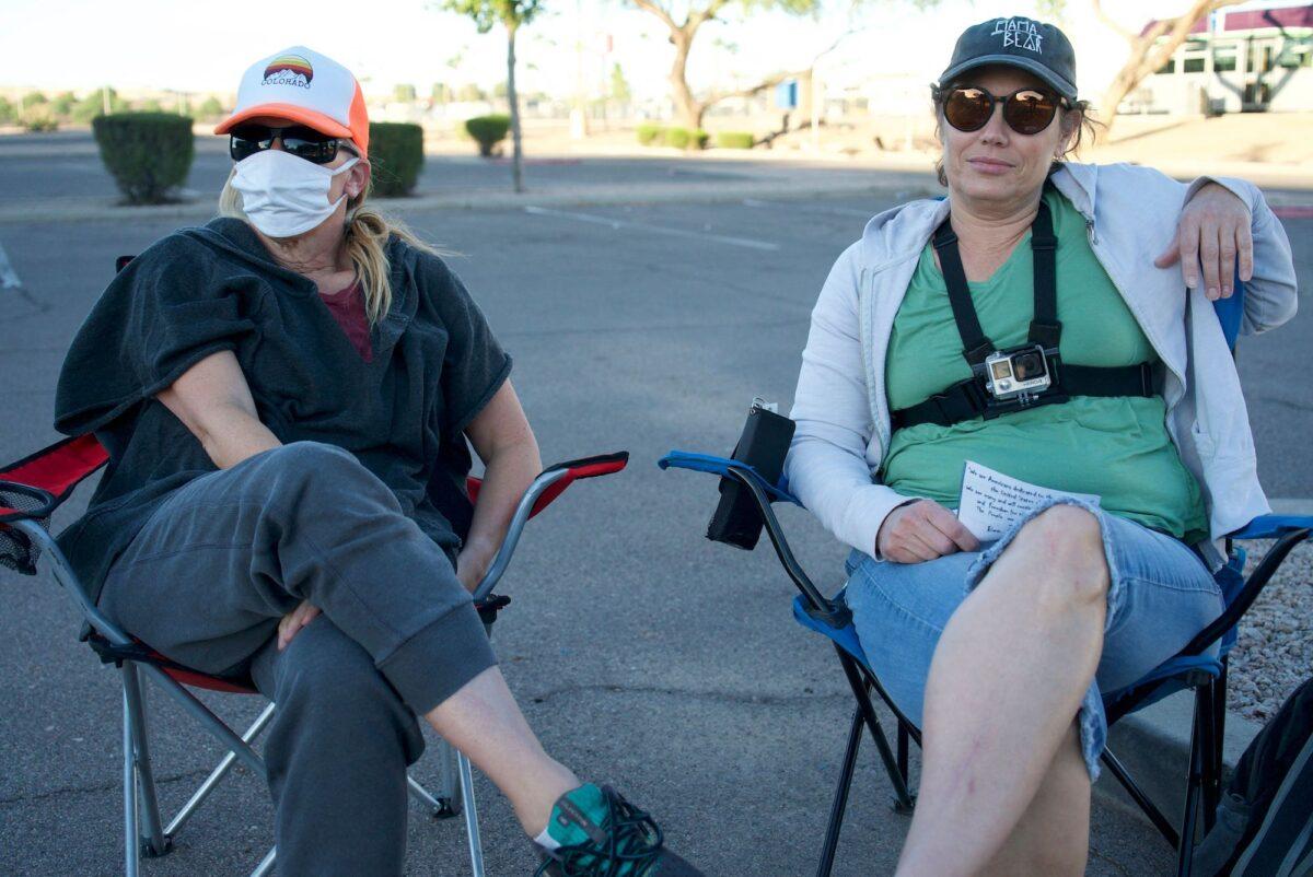 Lynnette (L), 50, and Nicole, 52, watch a ballot drop box while sitting in a parking lot in Mesa, Ariz., on Oct. 24, 2022. (Bastien Inzaurralde/AFP via Getty Images)