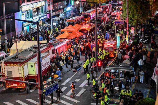 Onlookers, police, and paramedics gather where dozens of people suffered cardiac arrest, in the popular nightlife district of Itaewon in Seoul on Oct. 30, 2022. (Jung Yeon-Je/AFP via Getty Images)