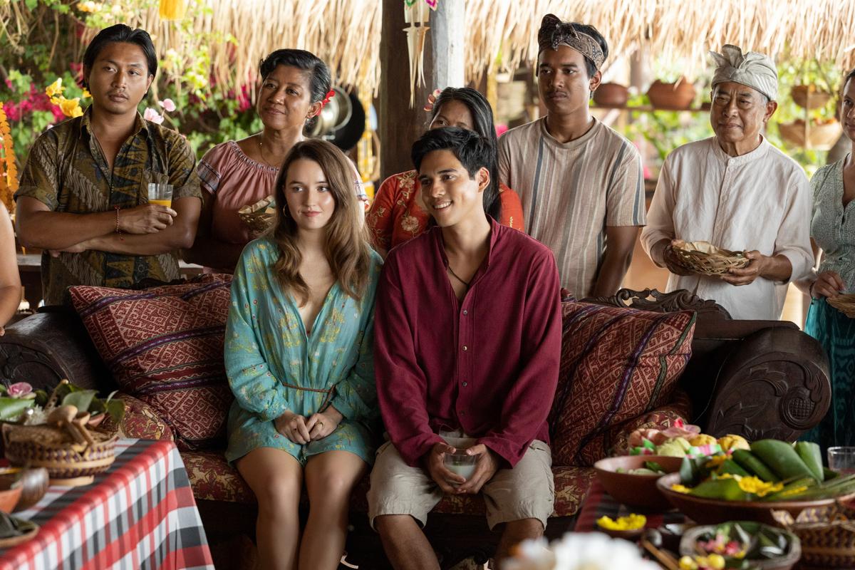 Law student Lily Cotton (Kaitlyn Dever, front L) and seaweed farmer Gede (Maxime Bouttier, C), with Gede's extended family, in "Ticket to Paradise." (Universal Pictures)