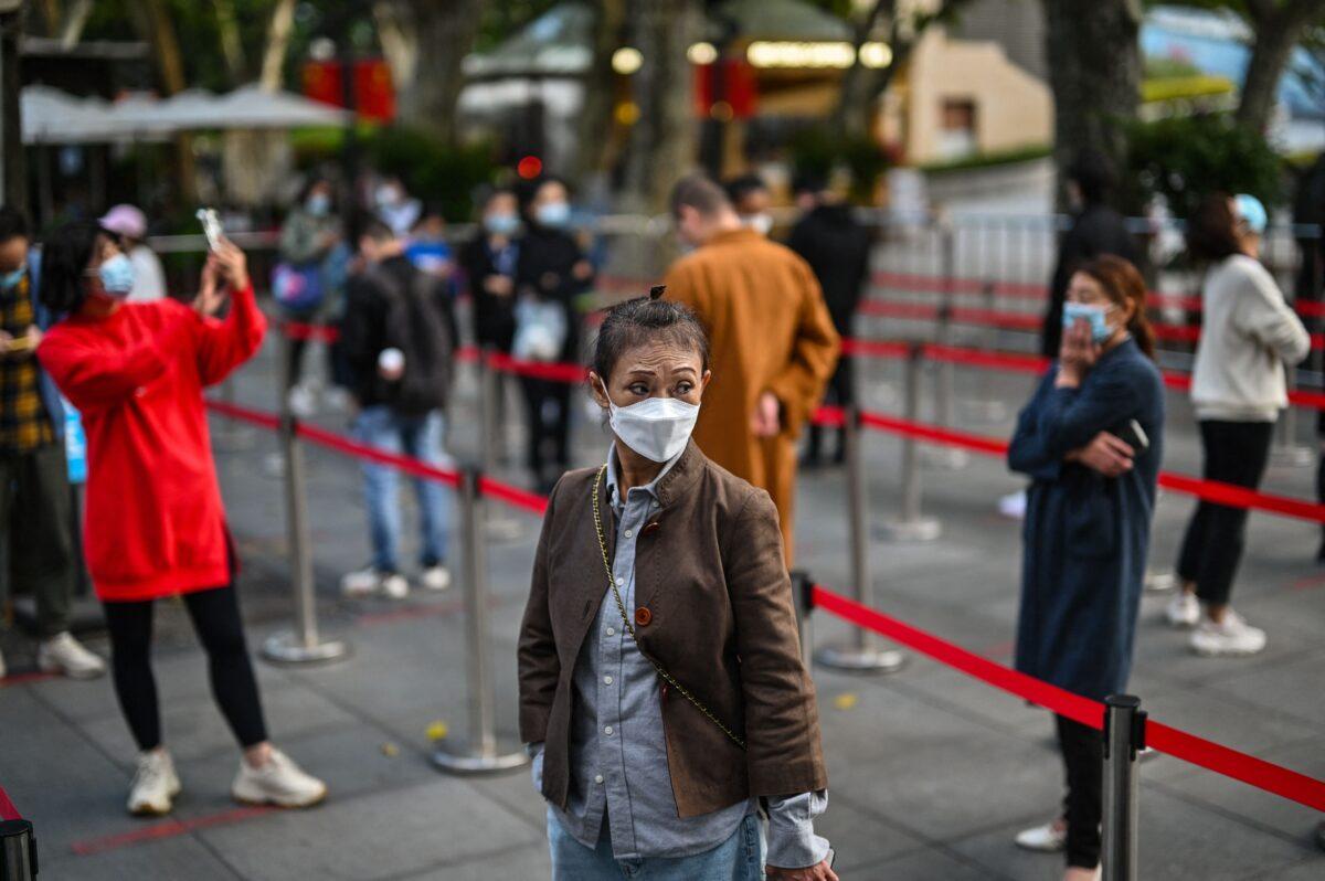 People wait in a line to test for COVID-19 in the Jing'an district in Shanghai on Oct. 25, 2022. (Hector Retamal/AFP via Getty Images)
