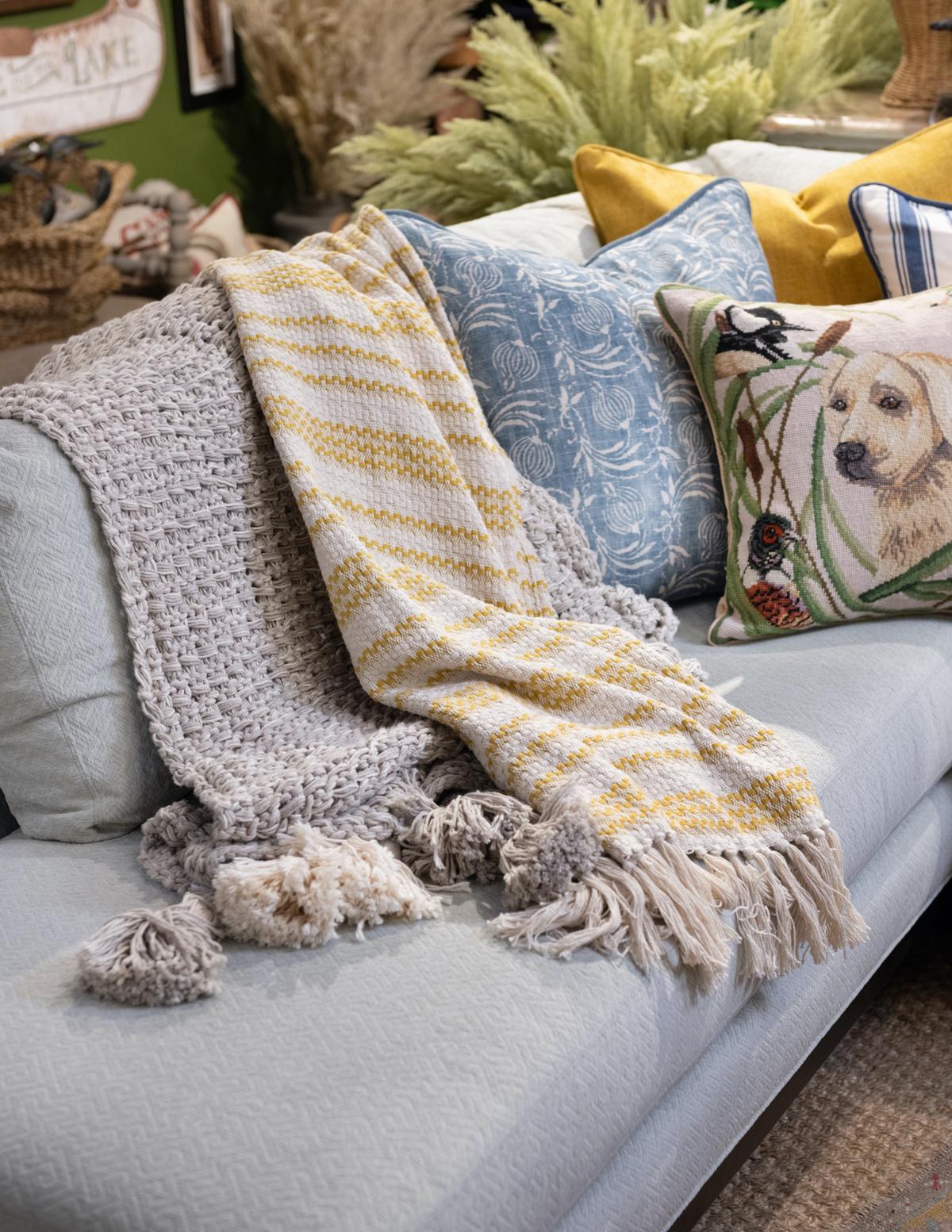 Two layered throw blankets make for a snuggly and inviting couch display. (Handout/TNS)