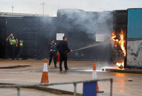 Members of the military and UK Border Force extinguish a fire from a petrol bomb, targeting the Border Force centre in Dover, Britain, on Oct. 30, 2022. (Reuters/Peter Nicholls)