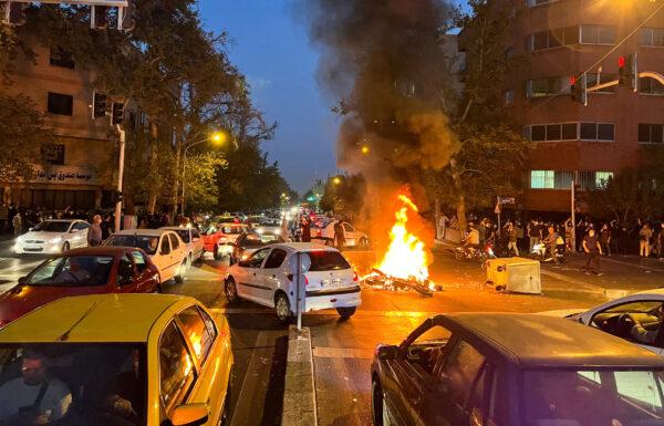 A police motorcycle burns during a protest over the death of Mahsa Amini, a woman who died after being arrested by the Islamic republic's "morality police", in Tehran, Iran, on Sept. 19, 2022. (West Asia News Agency via Reuters)
