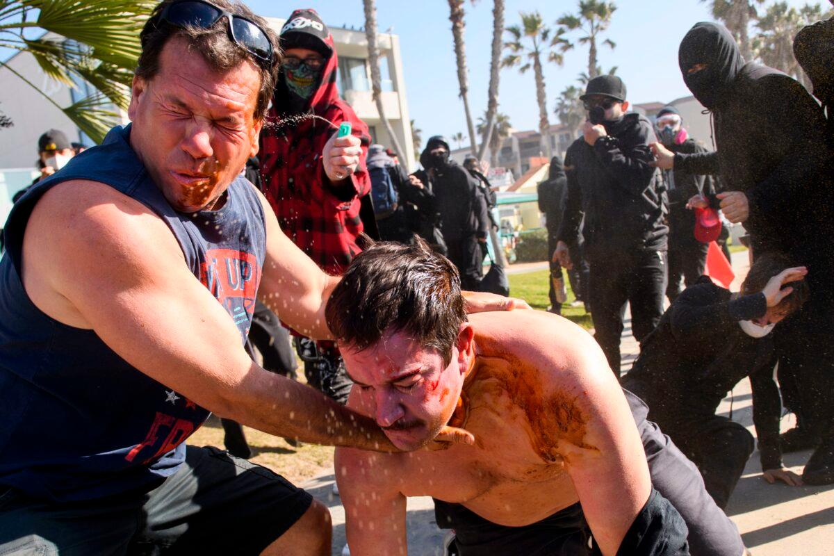  Counter-protesters spray demonstrators during a "Patriot March" demonstration in support of then President Donald Trump in the Pacific Beach neighborhood of San Diego on Jan. 9, 2021. (Patrick T. Fallon/AFP via Getty Images)