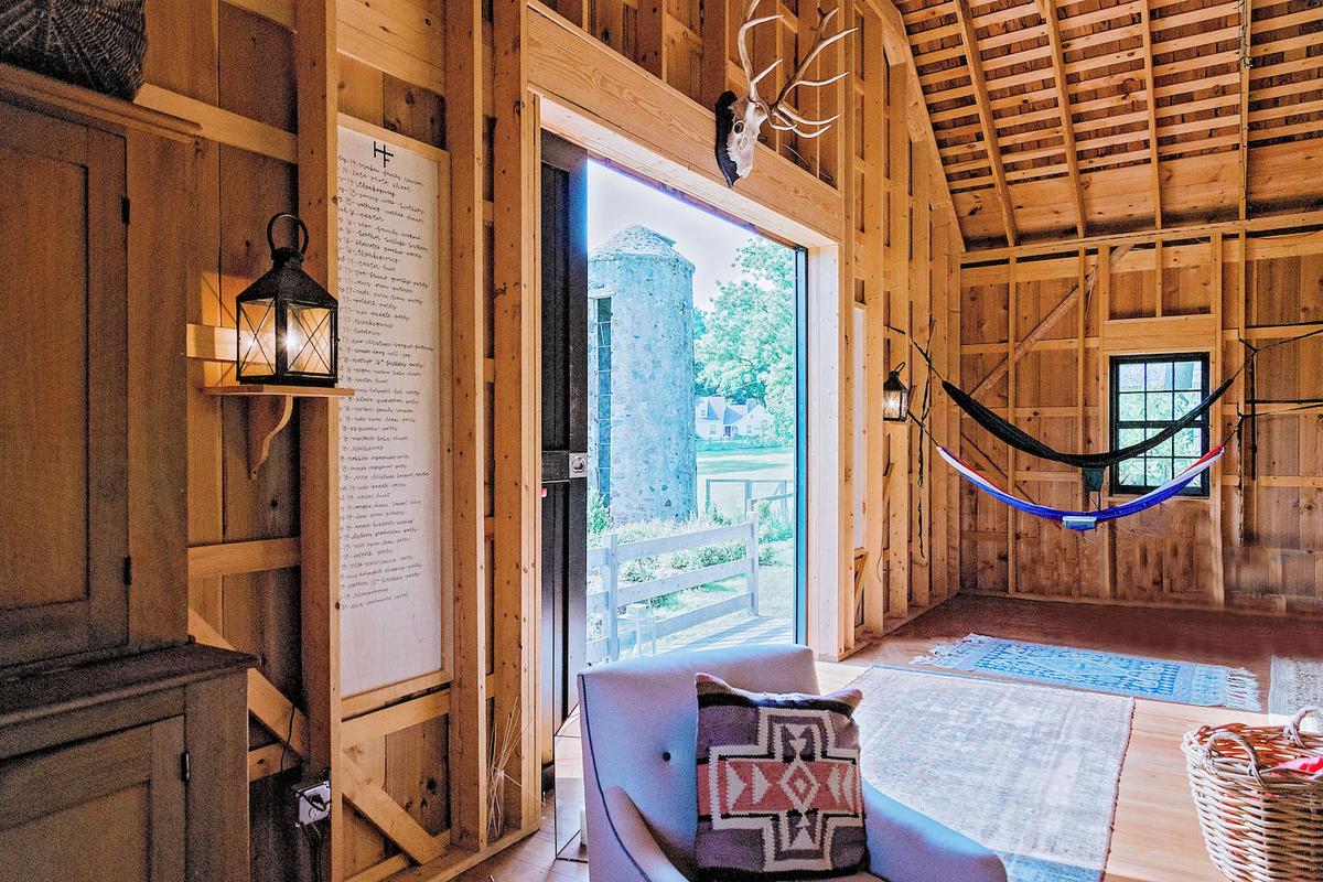 A detailed longboard hangs on either side of the barn doors, where the family notes down events to be held in the barn. (Courtesy of <a href="https://www.hungry4home.com/">Ruth McKeaney</a>)