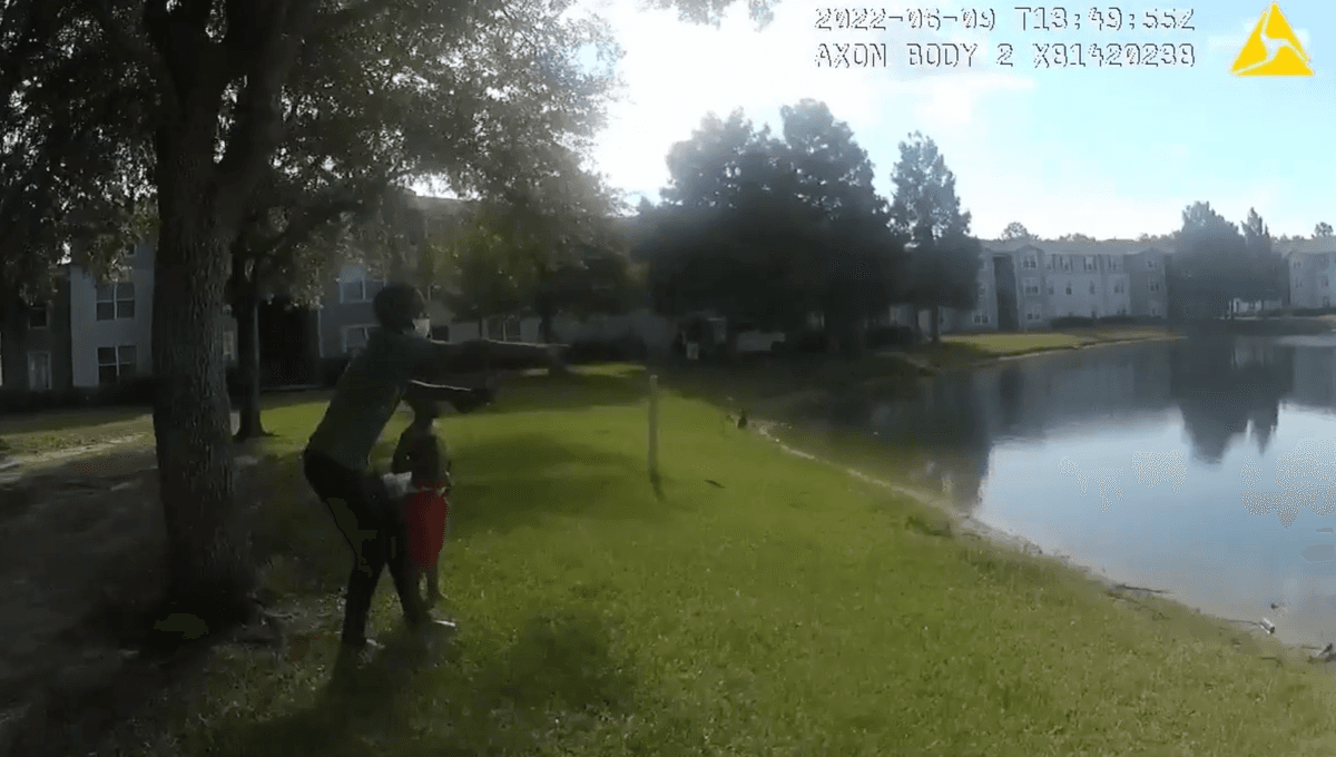 Body camera footage shows a bystander pointing into the pond at the Madelyn Oaks Apartments where an infant was submerged and drowning on June 9, 2022. (Courtesy of <a href="https://www.facebook.com/JacksonvilleSheriffsOffice">Jacksonville Sheriff's Office</a>)