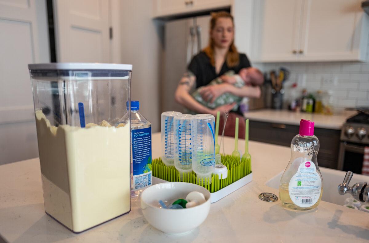 Baby formula sits in the kitchen of Daisy Strongin as she cradles her newborn son in northeastern Illinois on Nov. 1, 2022. (John Fredricks/The Epoch Times)
