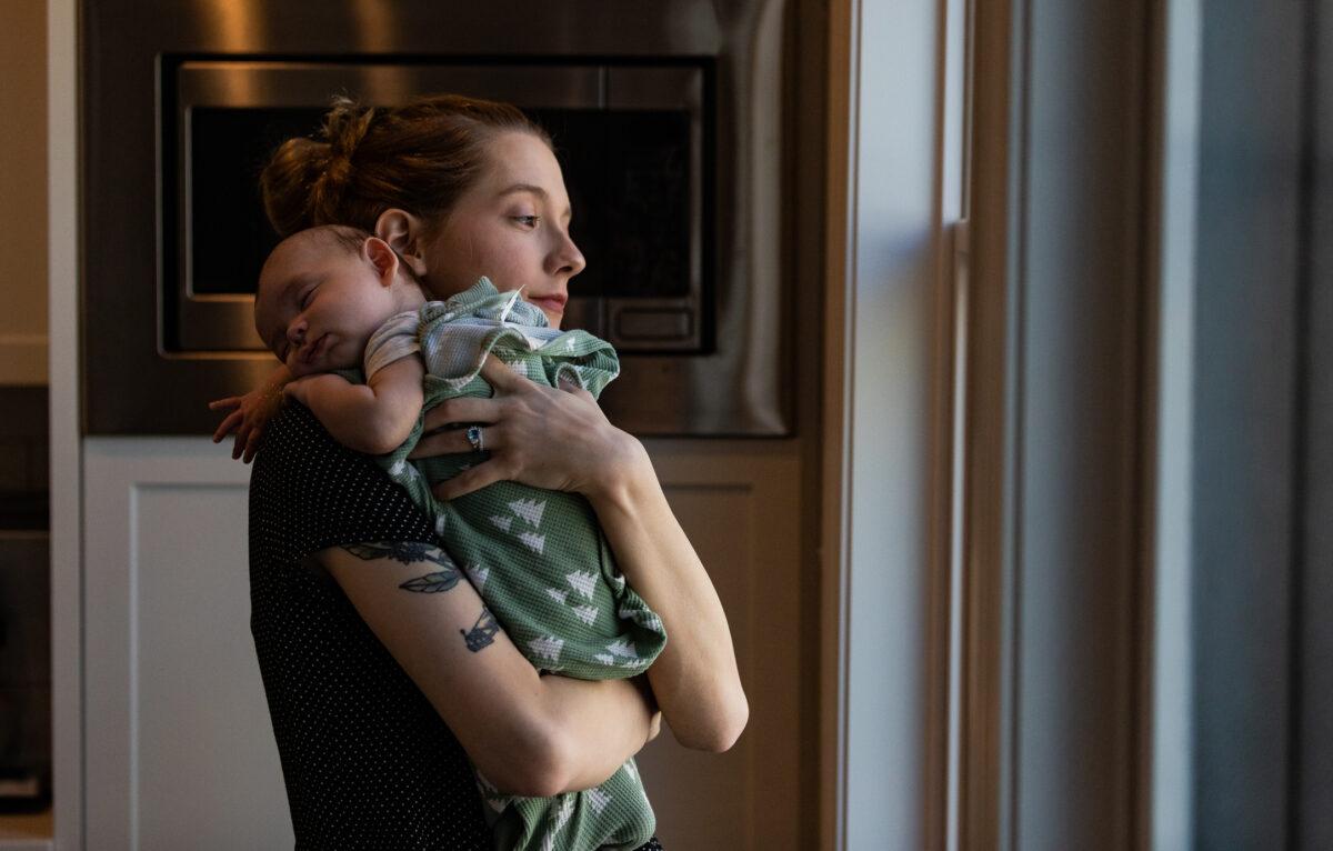 Detransitioner Daisy Strongin holds her son in northeastern Illinois on Nov. 1, 2022. (John Fredricks/The Epoch Times)