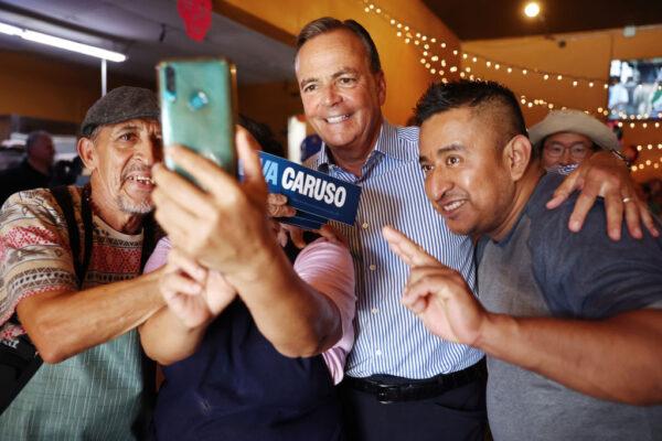 Los Angeles Democratic mayoral candidate Rick Caruso (C) poses for photos at a restaurant while campaigning in the Boyle Heights neighborhood, which is predominantly Latino, in East Los Angeles on Oct. 24, 2022. (Mario Tama/Getty Images)