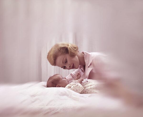 A mother leans lovingly above her newborn baby, ca.1950s. United States. (Photo by Tom Kelley/Getty Images)