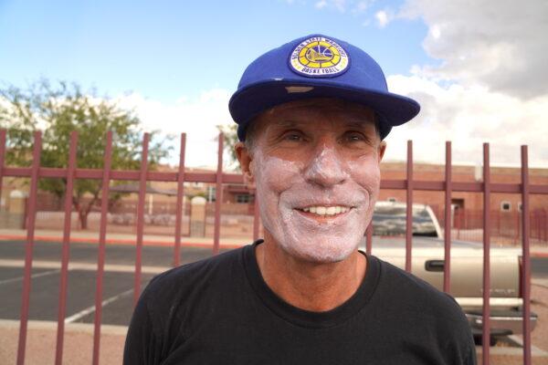 Jeff Gustavson of Mesa, Ariz., wearing sunscreen, stood in line with more than 1,000 people waiting to hear former President Barack Obama speak at a political rally in Phoenix on Nov. 2, 2022. (Allan Stein/The Epoch Times)